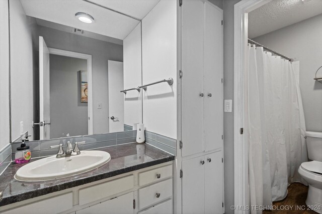 bathroom featuring vanity, curtained shower, and toilet