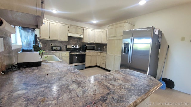 kitchen with tasteful backsplash, kitchen peninsula, and appliances with stainless steel finishes