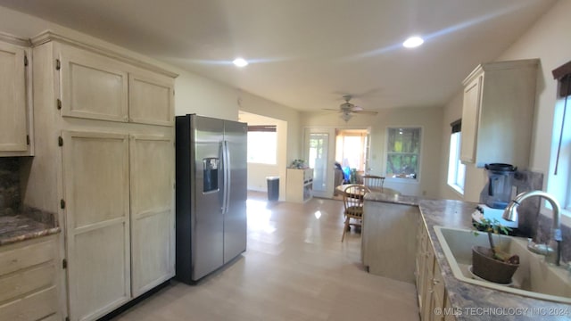 kitchen with stainless steel refrigerator with ice dispenser, ceiling fan, sink, cream cabinets, and light hardwood / wood-style floors