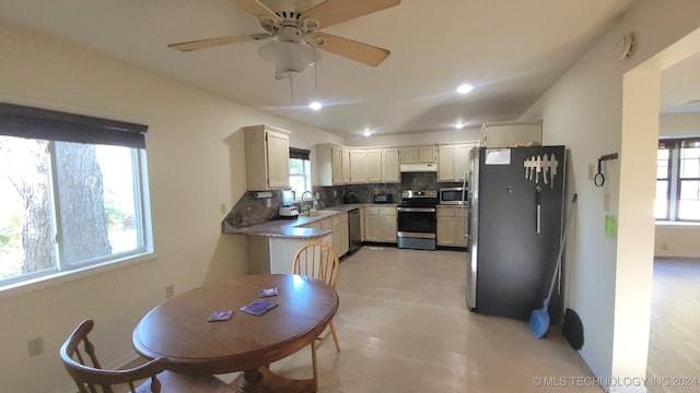 kitchen with sink, decorative backsplash, ceiling fan, light wood-type flooring, and stainless steel appliances