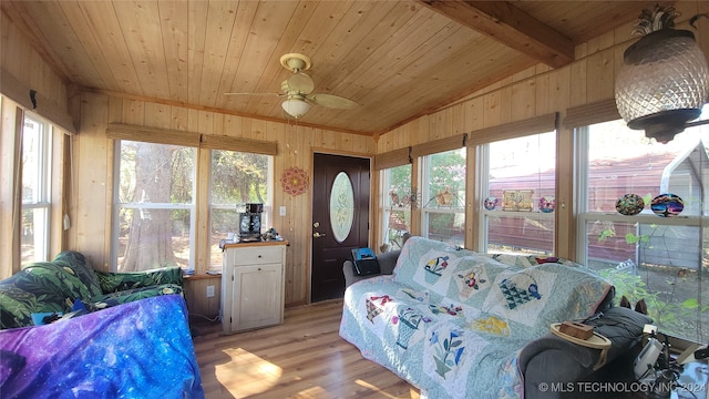 sunroom / solarium featuring wood ceiling, lofted ceiling with beams, ceiling fan, and a healthy amount of sunlight