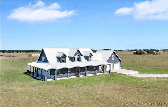 view of front facade featuring a garage, a front yard, a rural view, and covered porch