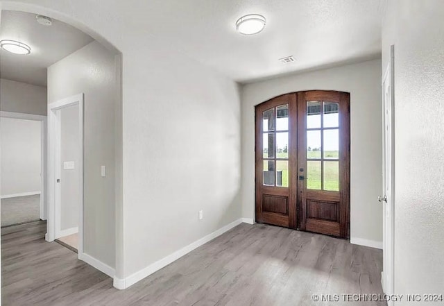 foyer featuring light hardwood / wood-style floors and french doors