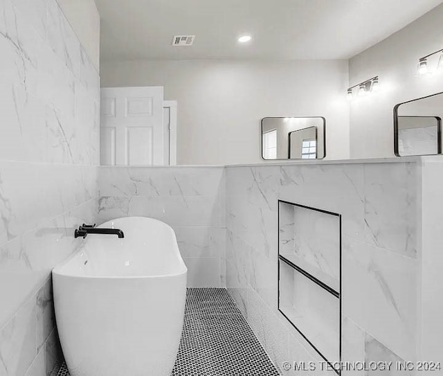 bathroom with a bathtub and tile walls