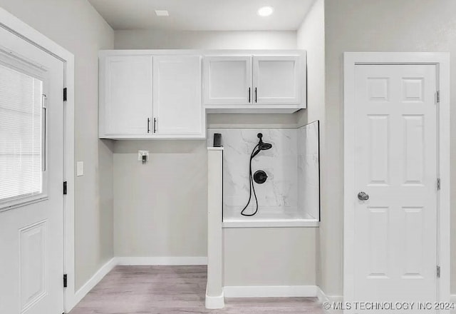 laundry room featuring light hardwood / wood-style floors and cabinets