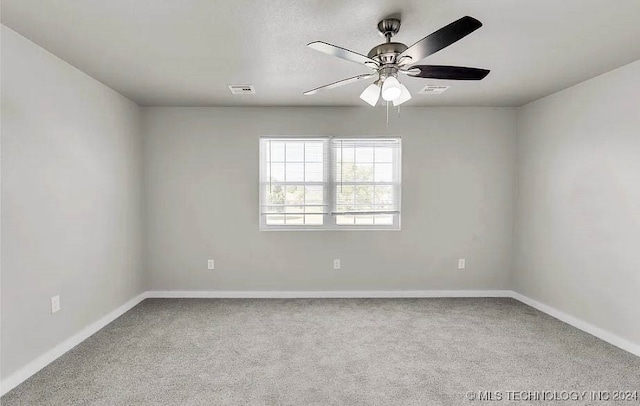 carpeted spare room featuring ceiling fan