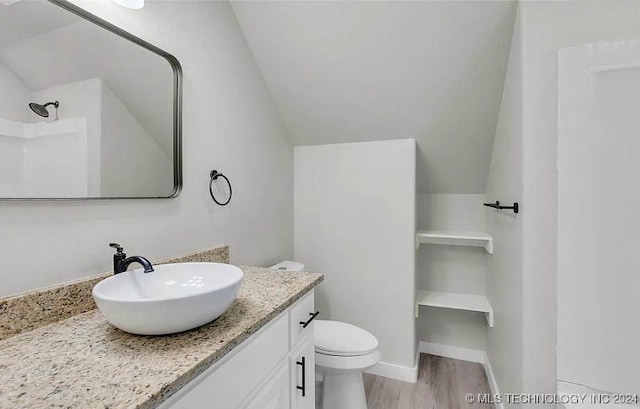 bathroom with walk in shower, lofted ceiling, toilet, vanity, and hardwood / wood-style flooring