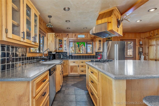 kitchen with stainless steel appliances, wooden walls, sink, light brown cabinets, and range hood