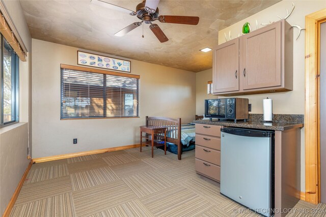 kitchen featuring ceiling fan, refrigerator, a healthy amount of sunlight, and light brown cabinets