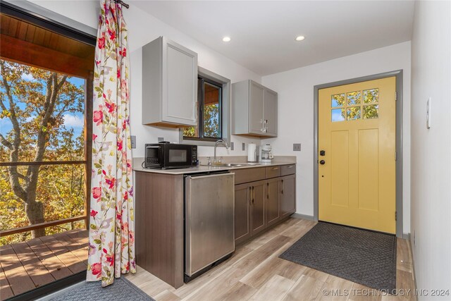 kitchen with dishwasher, light hardwood / wood-style floors, gray cabinetry, and sink