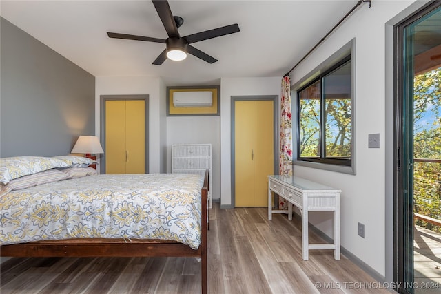 bedroom featuring hardwood / wood-style floors, ceiling fan, and a wall mounted AC