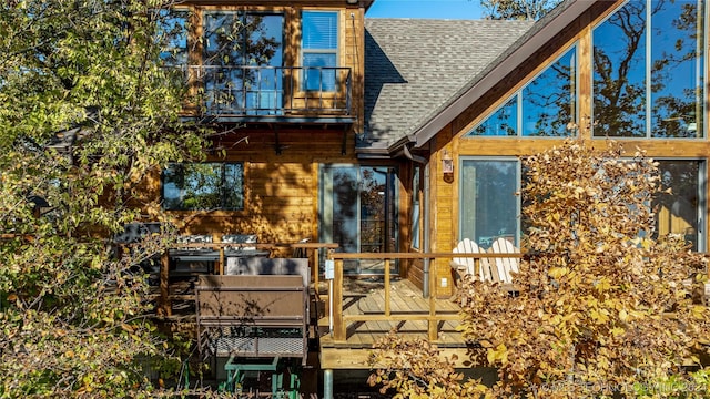 rear view of house with a balcony and a deck