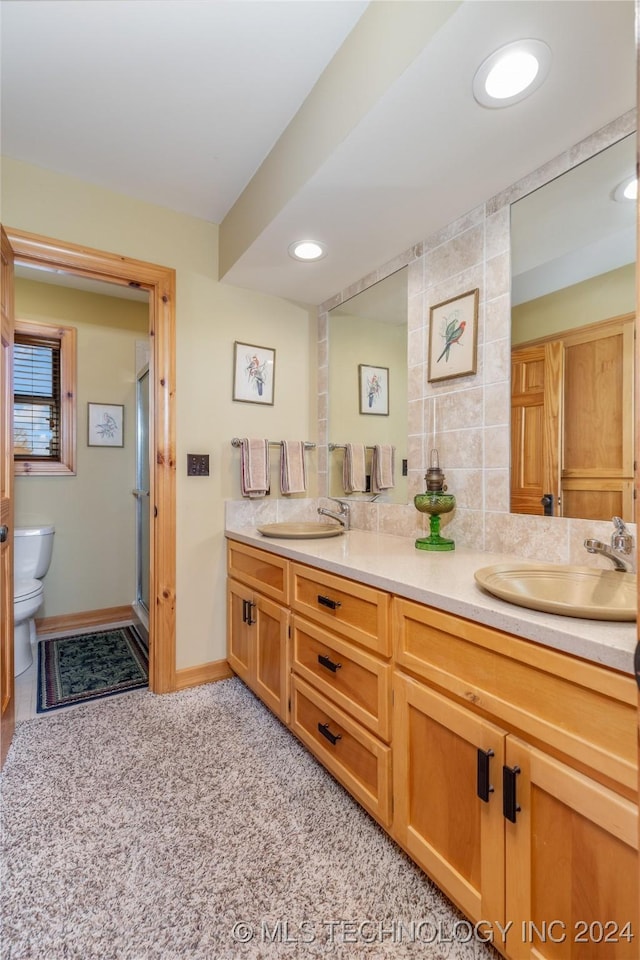 bathroom with walk in shower, backsplash, vanity, and toilet