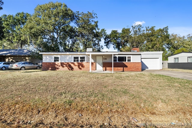 single story home featuring a front lawn and a garage