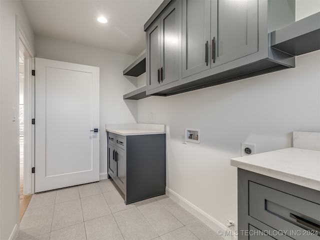 washroom with cabinets, hookup for a washing machine, light tile patterned flooring, and electric dryer hookup