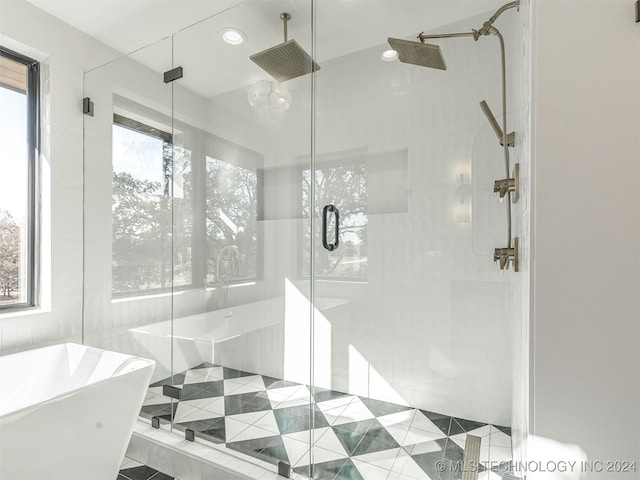 bathroom featuring plus walk in shower, tile patterned floors, and plenty of natural light