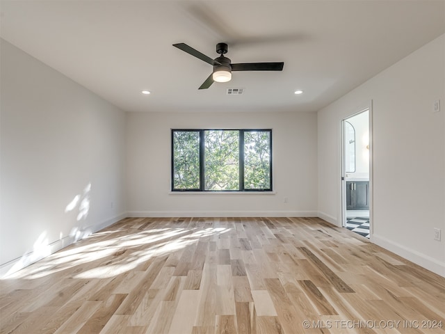 spare room with ceiling fan and light wood-type flooring