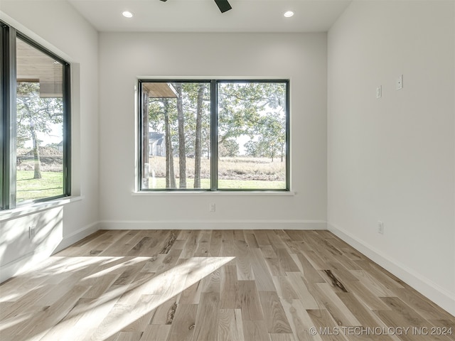 spare room featuring light hardwood / wood-style floors, a wealth of natural light, and ceiling fan