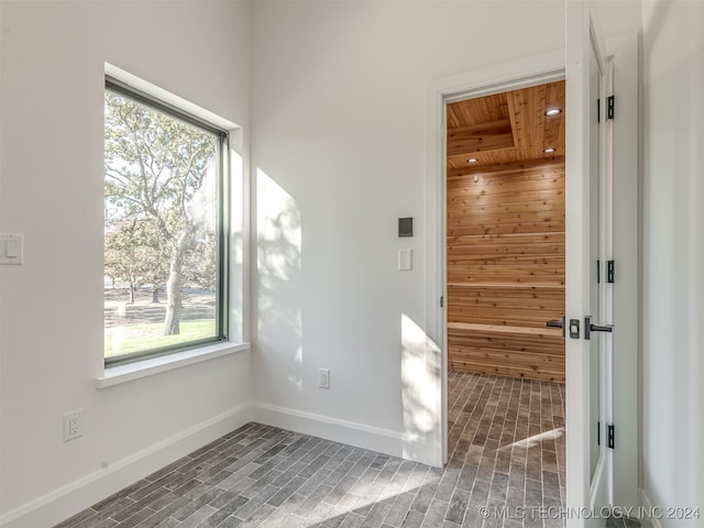 spare room featuring wood ceiling and a healthy amount of sunlight