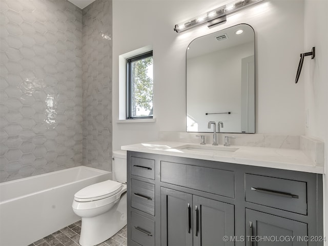 full bathroom with toilet, tiled shower / bath, vanity, and tile patterned flooring