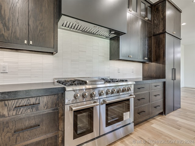 kitchen featuring decorative backsplash, light hardwood / wood-style floors, wall chimney exhaust hood, dark brown cabinetry, and double oven range