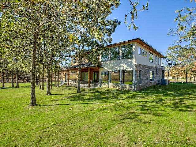 rear view of property with a yard and cooling unit