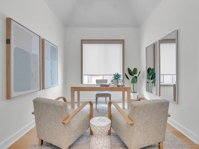 office space featuring a wealth of natural light, lofted ceiling, and light wood-type flooring