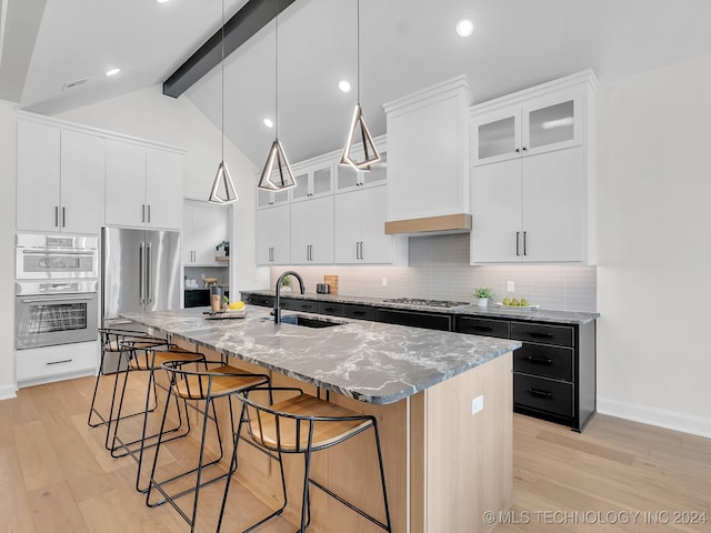 kitchen featuring white cabinets, light hardwood / wood-style floors, sink, and a kitchen island with sink