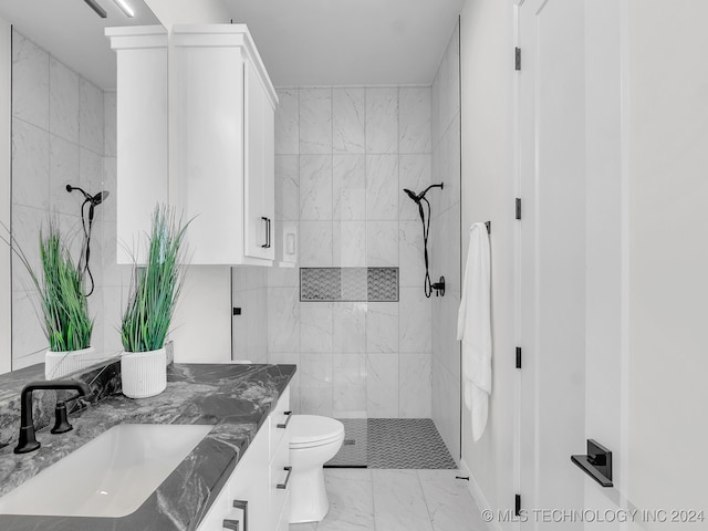 bathroom with vanity, toilet, tile walls, and tiled shower