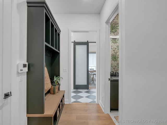 mudroom with light hardwood / wood-style flooring and a barn door