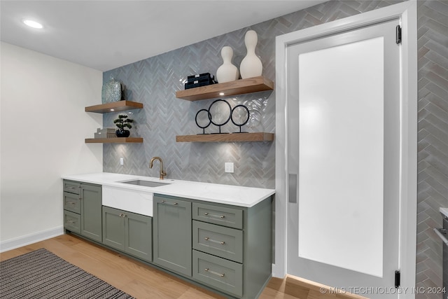 kitchen with light hardwood / wood-style floors, decorative backsplash, and sink