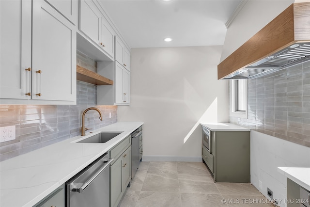 kitchen with custom range hood, light stone countertops, sink, and stainless steel dishwasher