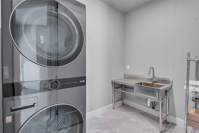 washroom featuring stacked washer and dryer and sink