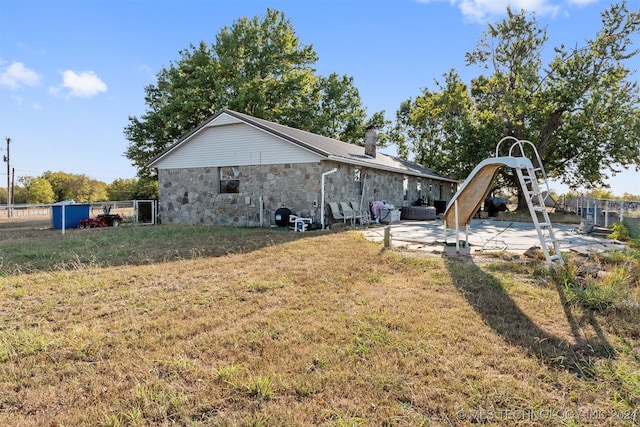 rear view of house featuring a patio and a yard