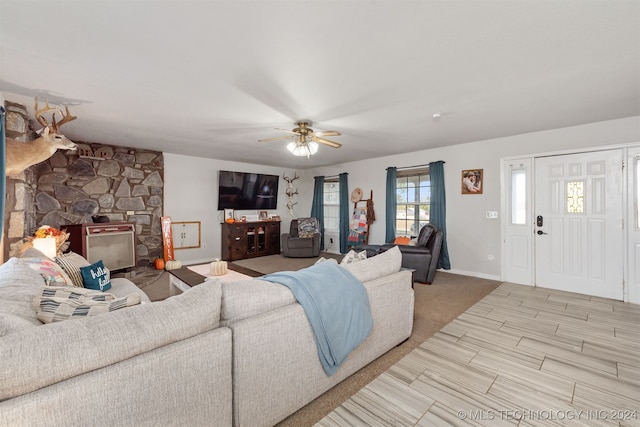 living room featuring a fireplace and ceiling fan