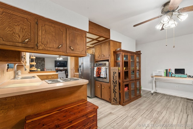 kitchen with sink, kitchen peninsula, stainless steel appliances, and ceiling fan