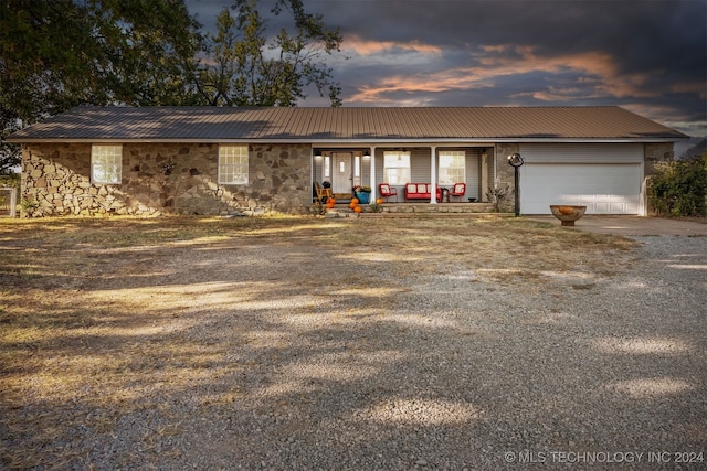 ranch-style house with a porch and a garage