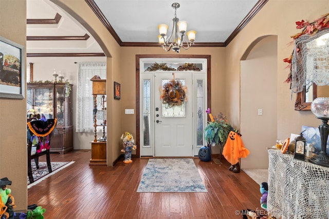 foyer featuring crown molding, a notable chandelier, and dark wood-type flooring