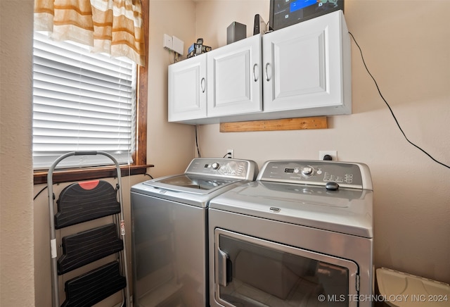 laundry area with washer and clothes dryer and cabinets