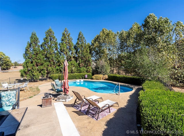 view of swimming pool featuring a patio and an outdoor fire pit