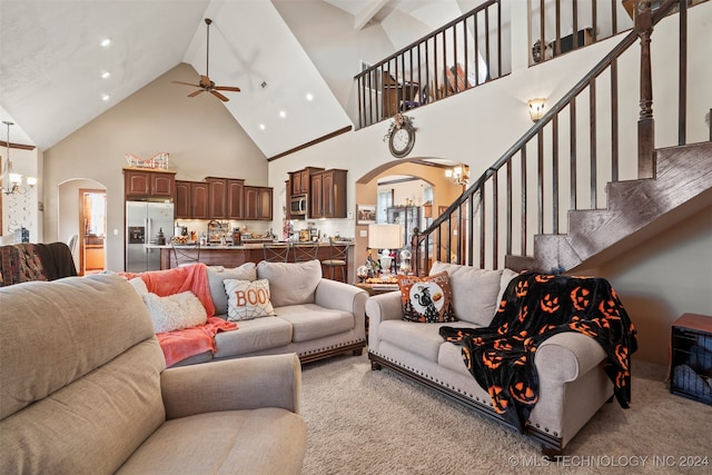 carpeted living room with ceiling fan with notable chandelier and high vaulted ceiling