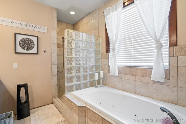 bathroom with independent shower and bath and tile patterned flooring