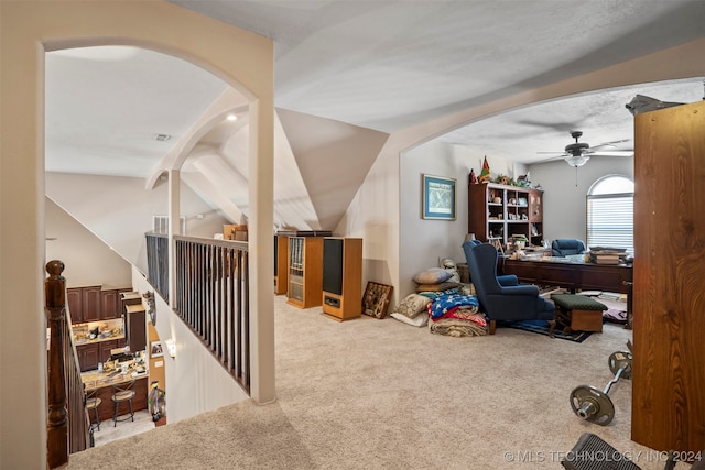 carpeted home office featuring ceiling fan and lofted ceiling