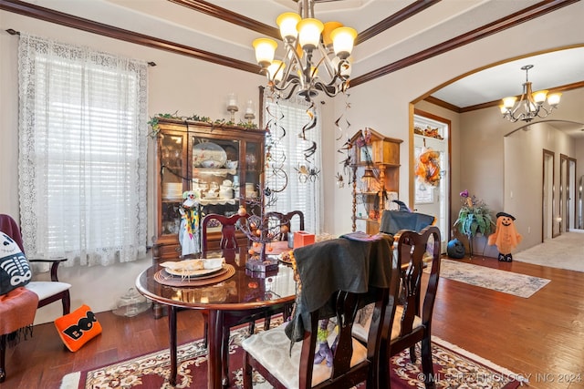 dining area with ornamental molding, a chandelier, and hardwood / wood-style flooring