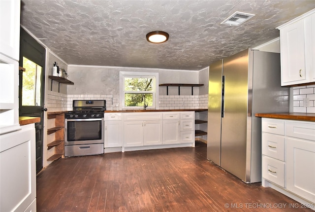 kitchen with white cabinetry, appliances with stainless steel finishes, dark hardwood / wood-style floors, and wooden counters