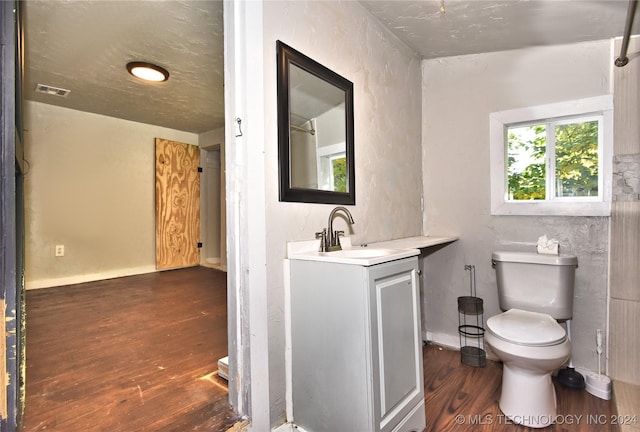 bathroom featuring wood-type flooring, vanity, and toilet