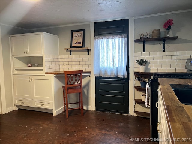 kitchen with white cabinetry, butcher block countertops, and decorative backsplash