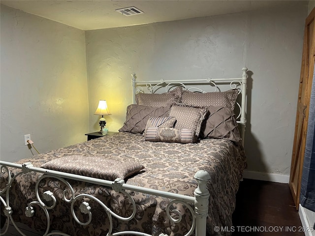 bedroom with dark wood-type flooring