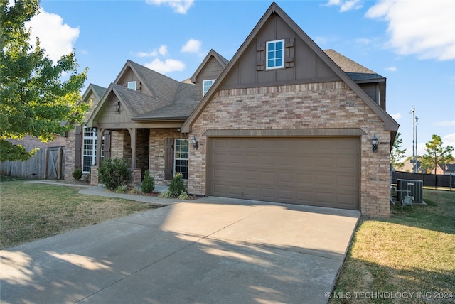 craftsman-style home with a front lawn, central AC unit, and a garage