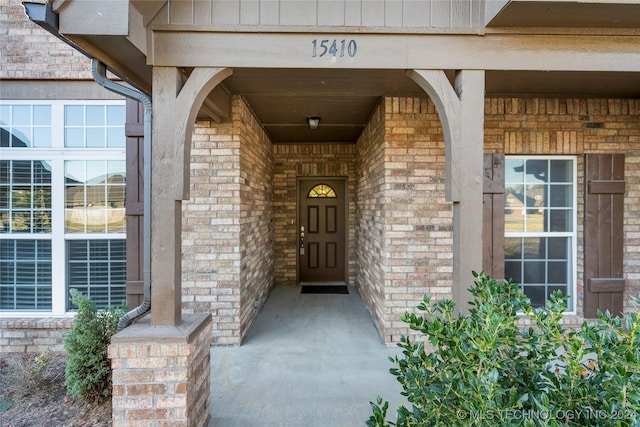 15410 E 87th St, Owasso, OK 74055 - doorway to property with brick siding, a porch, and board and batten siding